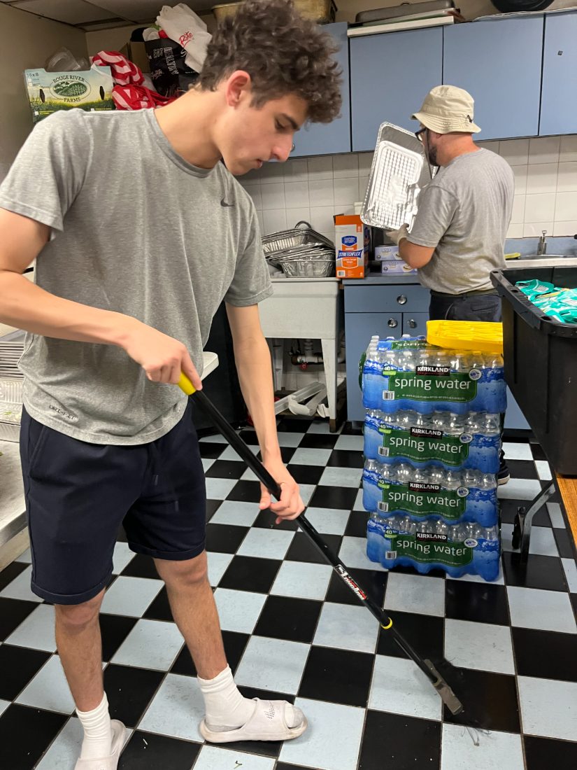 Daniel mopping the kitchen floor during cleanup