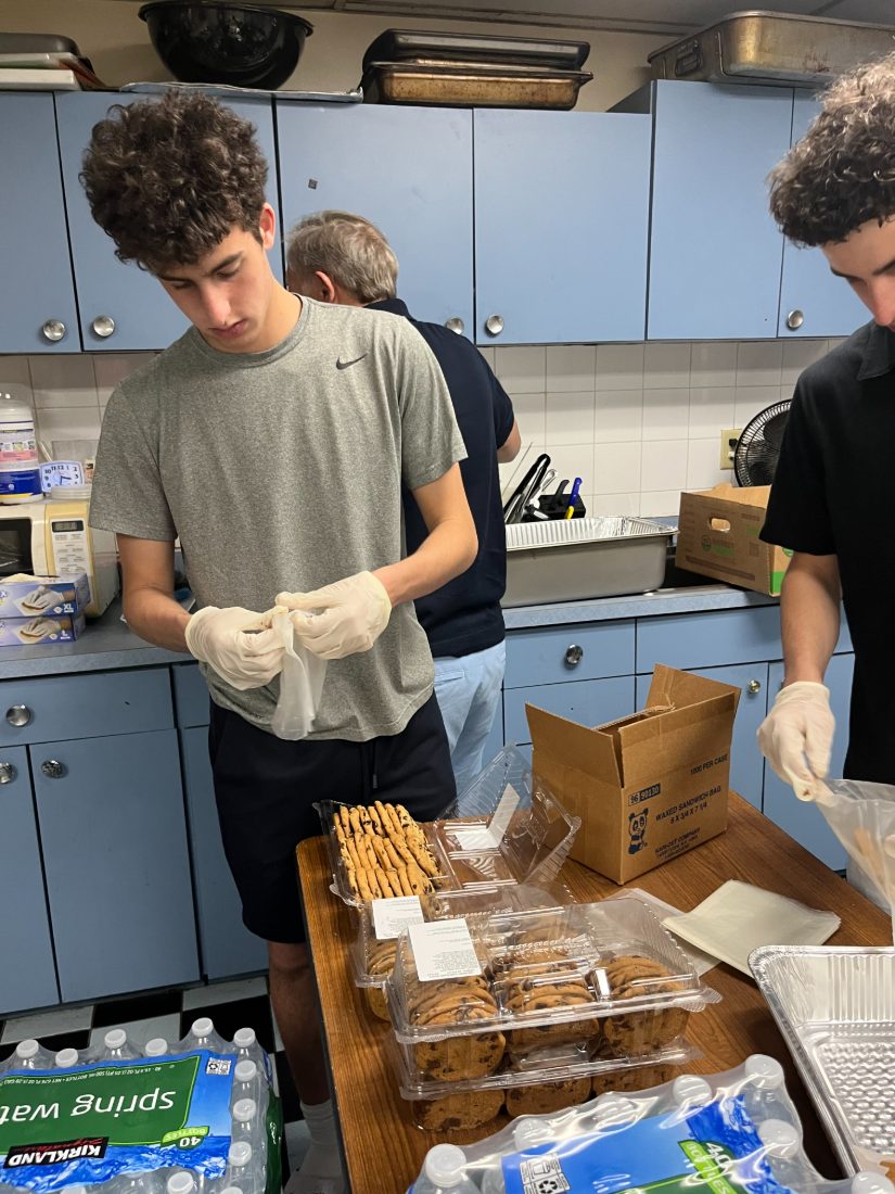 Daniel and Liam bagging cookies and sandwiches for delivery